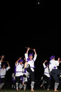 中秋の名月の下で勇壮な演舞を披露する男性たち＝６日、野原公民館