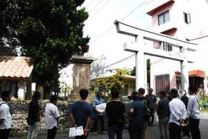 中村さん（中央）から宮古の歴史などの説明を受ける参加者＝24日、漲水御嶽前