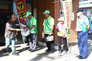 「特殊詐欺に注意して」と声を掛けながら冊子と菓子を配布した広報啓発活動＝15日、琉球銀行宮古支店前