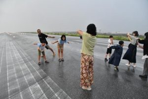 小雨が降る中、滑走路で記念撮影する親子連れ＝26日、宮古空港