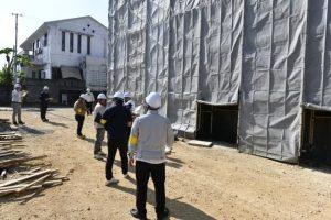 工事中の建築現場を訪れ建築現場の安全対策などを確認する参加者＝15日、平良西里