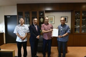 嘉数市長（右）に意見書を提出した砂川会長ら振興会議のメンバー＝15日、市役所応接室