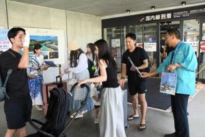鶴見社長や観光協会職員らが記念品をプレゼントして利用客を歓迎した＝１日、みやこ下地島空港ターミナル