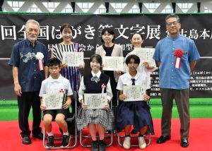 表彰状を手にする受賞者ら。前列中央は大賞の藤井さん＝26日、ＪＴＡドーム宮古島