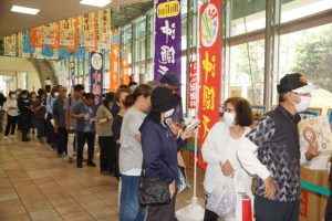 好みの袋麺を買い求めて並ぶ来場者＝16日、那覇中央郵便局