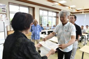 サトウキビ生産量１位の池田さん（右）ら優秀な成績を残した農家を表彰した＝15日、吉田公民館