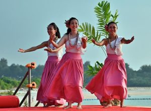 青い空の下、フラを披露する参加者ら＝12日、トゥリバー海浜公園