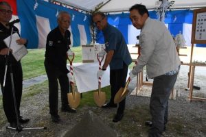 無事故無災害でのプール設置を願ってくわ入れする嘉数市長（右から2人目）ら＝9日、伊良部島小中学校