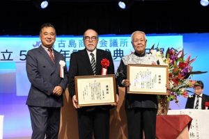 記念式典で(左から)根路銘会頭が特別功労者として下地さん、黒島さんを表彰した=27日、ホテルアトールエメラルド宮古島