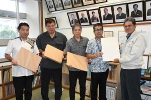 友利代表（右）からバガス紙を受け取る松原校長ら＝11日、宮古高校