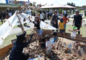 草花あそびブースで笑顔いっぱい遊ぶ子供たち=16日、パイナガマ海空すこやか公園