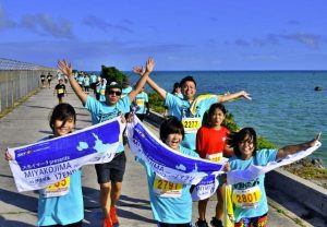笑顔でゴールを目指す参加者ら=9日、下地島空港の空港管理道路