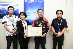 受賞した砂川さん(中央右)とJALスカイエアポート沖縄宮古空港所の皆さん=26日、宮古空港