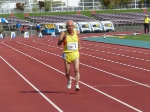 M100(男子100~104歳)クラスの100でメートル世界記録を更新した亀濱さんの走り=2日、沖縄市の県総合運動公園