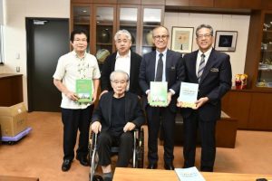 自伝本を市に寄贈した西里さん（前）＝28日、市役所