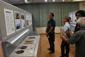 水中文化遺産展に見入る宮城教育長(左)ら=13日、市歴史文化資料館