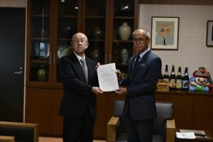 審議結果の答申書を嘉数市長(右)に手渡す庄司副会長=19日、市役所