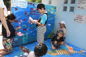 願いを込めて「拾い箱」にペイントする子供たち＝１日、パイナガマビーチ