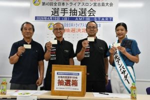 抽選用紙を手にする(左から)砂川選考委員長、嘉数大会長、砂川実行委員長、小林さん=11日、市役所