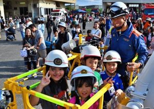 はしご車に乗車する子供たち＝15日、市消防本部