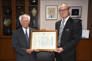 嘉数市長から宮古島市初の市民栄誉賞を受けた亀濱さん（左）＝18日、市役所