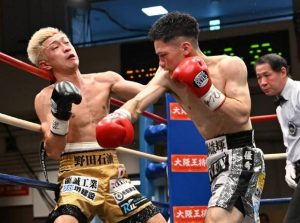 連打で相手を追い詰める川満（右）＝９日、東京の後楽園ホール（沖縄タイムス社提供）