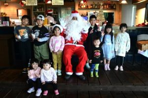 クリスマスマーケットでサンタクロースと記念撮影する子供たち＝20日、ＲｕＧｕｂｉｓｔｒｏ