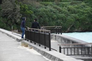 寒風に身を縮こませながら海を眺める姿が見られた＝26日、パイナガマビーチ