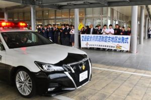 出発式後はパトカーなどの車両を拍手で見送った＝18日、市役所