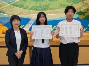 善行賞表彰を受けた石原さん（中央）、島袋さん（同右）＝６日、村コミュニティー施設