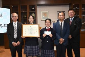 （左から）嘉数市長から表彰を受けた宮総実環境班の本村部長、渡真利さん、担当の前里和洋教諭、船越秀輝校長＝18日、市役所