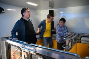 地震体験車で震度７の揺れを体験した来場者＝21日、ＪＴＡドーム宮古島