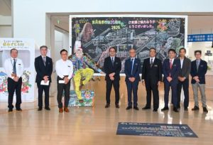 宮城教育長（右から４人目）による力作が飾られた黒板アートのオープニングセレモニー＝17日、市役所
