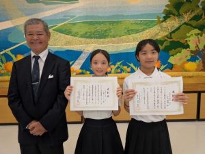 善行賞表彰を受けた栁岡さん（中央）、糸洲さん（同右）＝６日、村コミュニティー施設