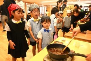 糖蜜を煮詰めて黒糖作りを体験した園児と保護者＝26日、はなぞのこどもえん