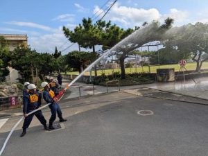 出初式でポンプ操法を行う団員ら＝６日、多良間村
