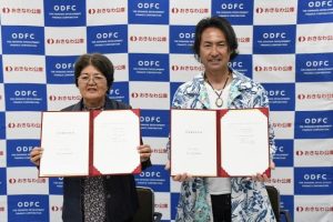 契約書を交わした上里氏(左)、中村代表(右)=30日、沖縄振興開発金融公庫宮古支店