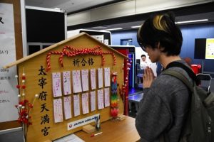 特大絵馬に願い事をする空港利用者＝14日、宮古空港