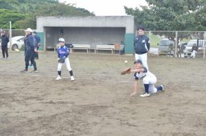 基礎練習でキャッチボールの様子を見守る伊志嶺さん（右奥）＝３日、市営球場