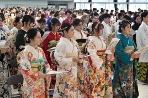 「二十歳を祝う会」の式典で市歌を斉唱する出席者＝５日、ＪＴＡドーム宮古島