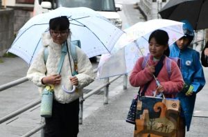 寒さや雨に負けずに笑顔で登校する児童たち＝21日、平良下里