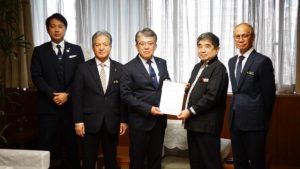 離島の医療体制の改善などを求め、池田副知事（中央右）へ要請書を手交した、県離島振興協議会の宮里会長（中央）や嘉数市長（右）ら＝28日、県庁