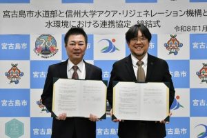 協定書を手にする砂川部長（左）と手嶋機構長＝９日、市役所