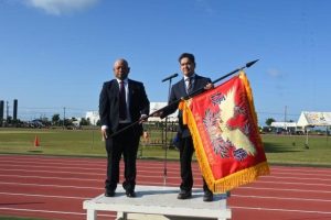 平良代表（左）が與那覇会長に優勝旗を寄贈した＝24日、市陸上競技場