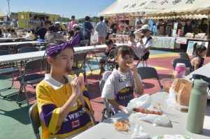 フードブースで料理を食べる来場者たち＝15日、ＪＴＡドーム宮古島