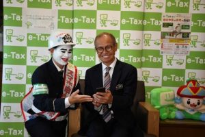 嘉数市長（右）が実際にスマホ申告を体験した＝13日、市役所