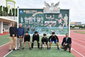 駅伝大会を盛り上げる黒板アートを描いた生徒と関係者ら ＝４日、市陸上競技場