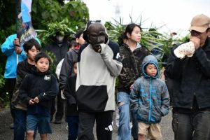 パーントゥの面をかぶった子どもを先頭に子どもや女性たちが集落を練り歩いて厄を払った「野原のパーントゥ」＝８日、上野野原集落