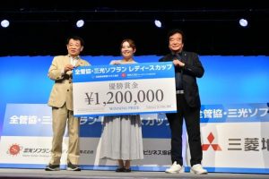 高橋大会長（右）から賞金の目録を受け取る佐々木さん（中央）。左は水野会長＝19日、ホテルアトールエメラルド宮古島