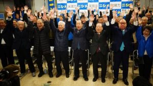８期目の当選を果たし支持者らと共に「万歳三唱」をする西銘恒三郎氏（前列中央）＝８日、南風原町の選対本部事務所